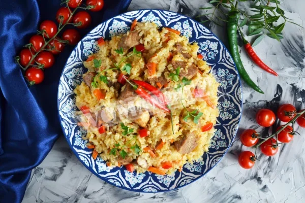 Плов зі свинини на сковороді на плиті, розсипчастий