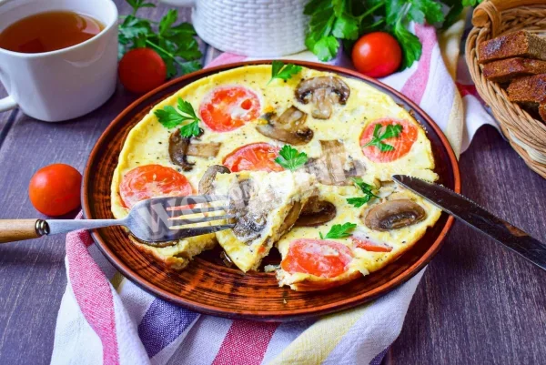 Омлет з грибами і сиром на сковороді на сніданок