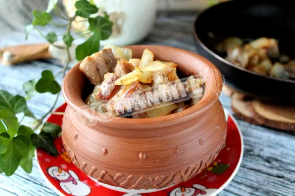 Шматочки свинини на сковороді з цибулею