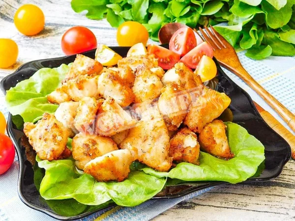 Шматочки курячого філе на сковороді