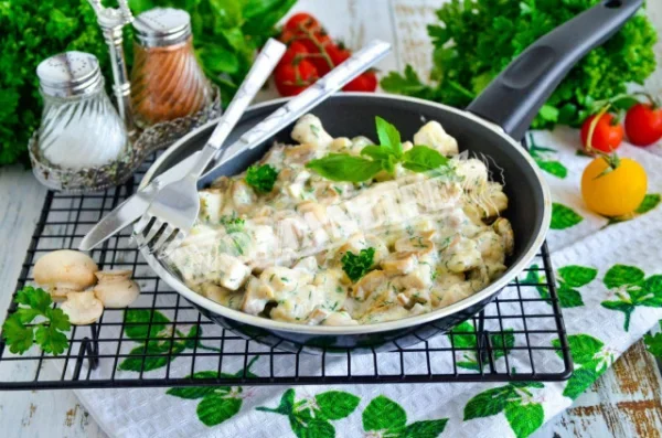 Курка з вершками і грибами на сковороді