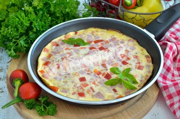 Пишний омлет з молоком і ковбасою на сковороді