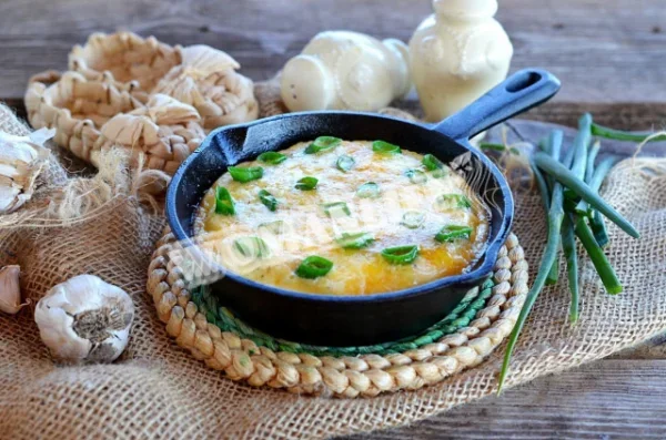 Омлет із зеленою цибулею на сковороді