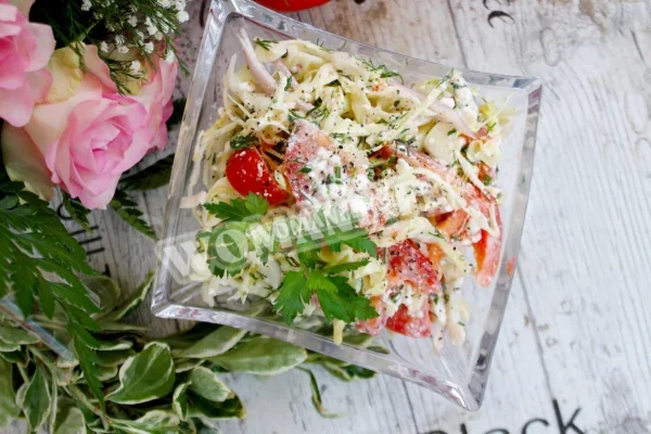 Салат з молодої капусти з помідорами і сиром.