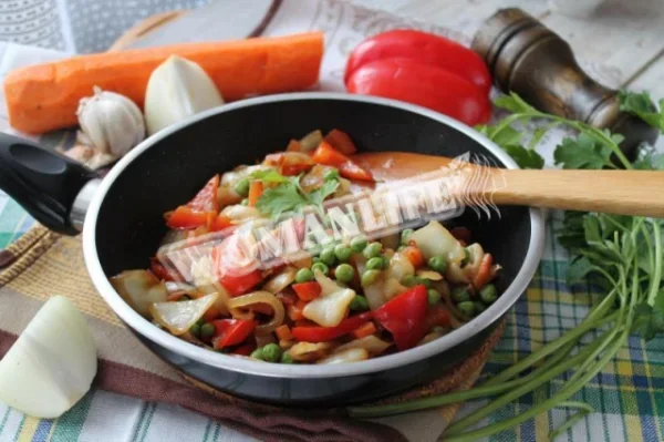 Тушкована капуста, перець, цибуля, морква на сковороді