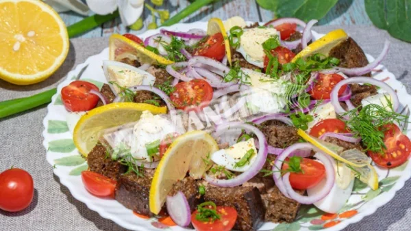 Класичний салат з печінки тріски з грінками і помідорами