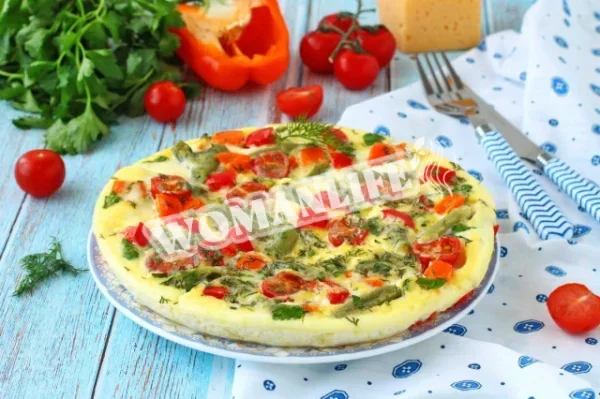 Омлет з овочами, сиром і зеленню на сковороді